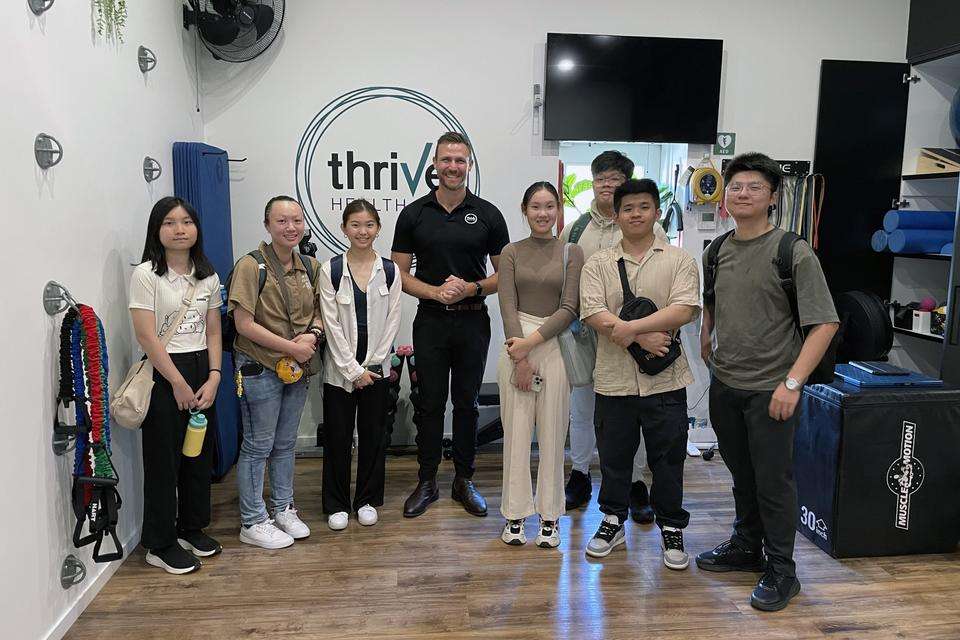 A group of men and women standing in a physiotherapy lab