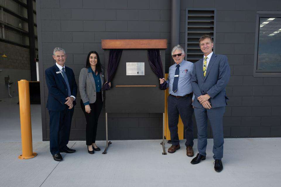 L-R: CQU Mackay Associate Vice Vice President Professor Rob Brown, Mackay Councillors Nathenea Macrae and Peter Sheedy and Peter Sheedy at the opening of the new Oorlea heavy automotive trades training facility. The group stands alongside the building opening plaque.