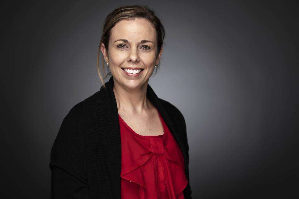 Amanda Clarke smiles at the camera in front of a grey indoor background.