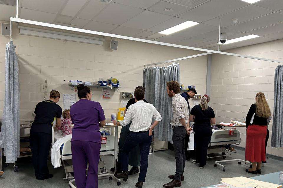 Medical and nursing students debrief in a simulated hospital setting.