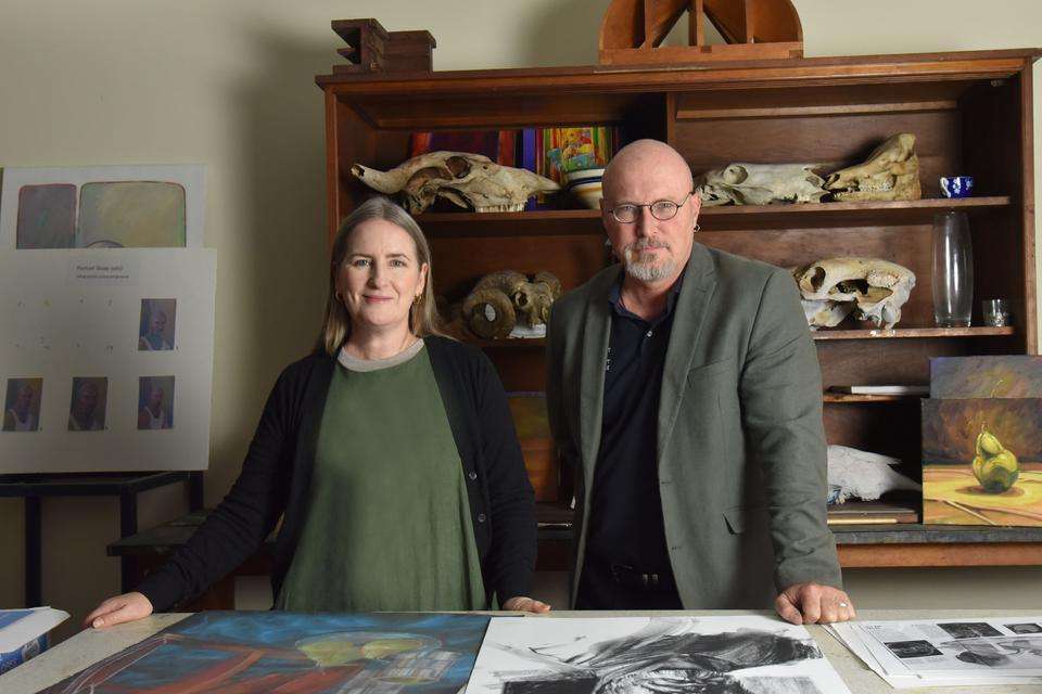 An image of a man and a woman standing in an art studio environment
