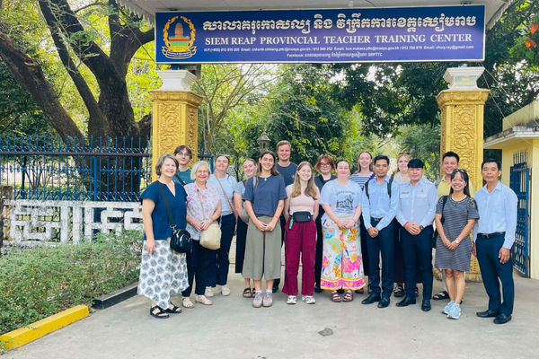 Group of people standing in front of a sign