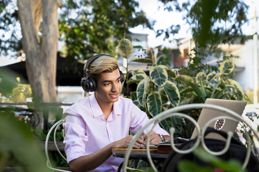 CQU student sitting on campus working on his laptop