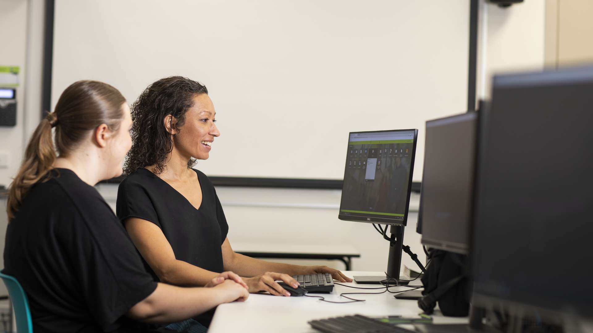 Digital Media students smiling at a computer