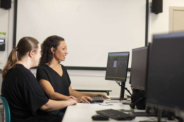 Digital Media students smiling at a computer