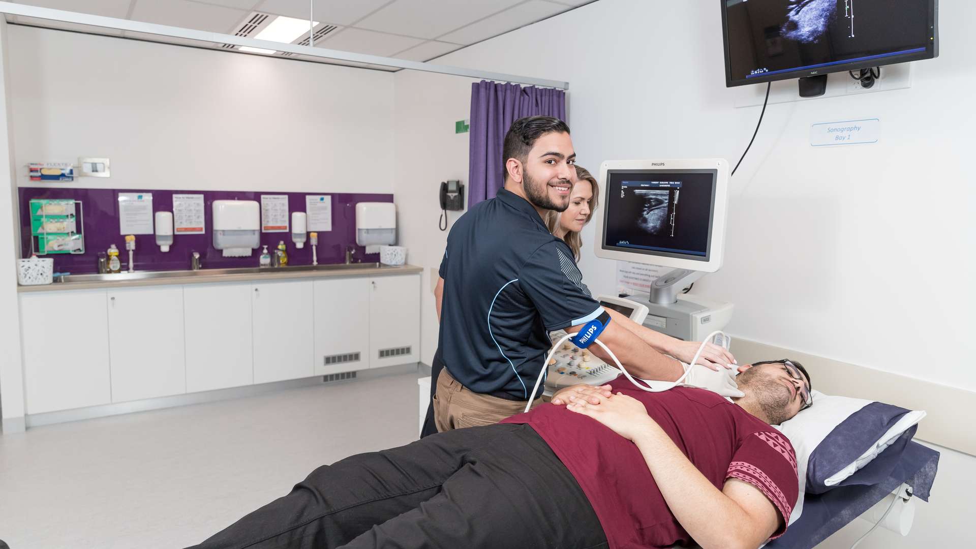 Sonography student working with a patient in a medical lab