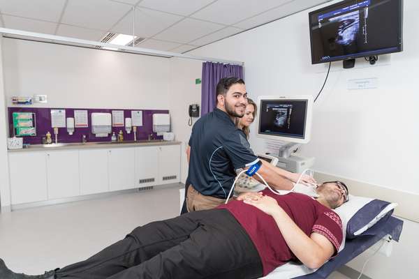 Sonography student working with a patient in a medical lab