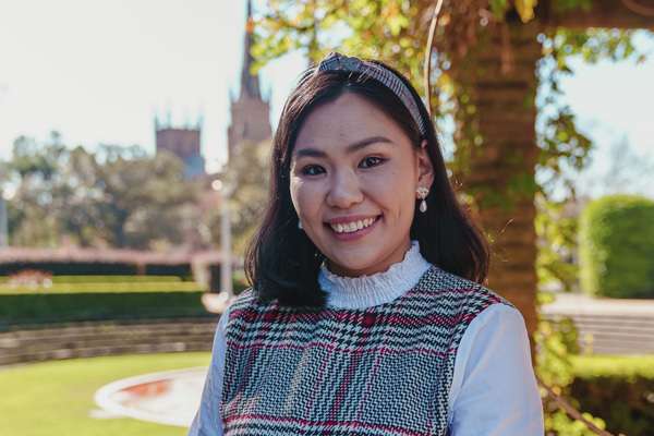 Oyunzaya Zaya posing in a Melbourne park smiling at the camera