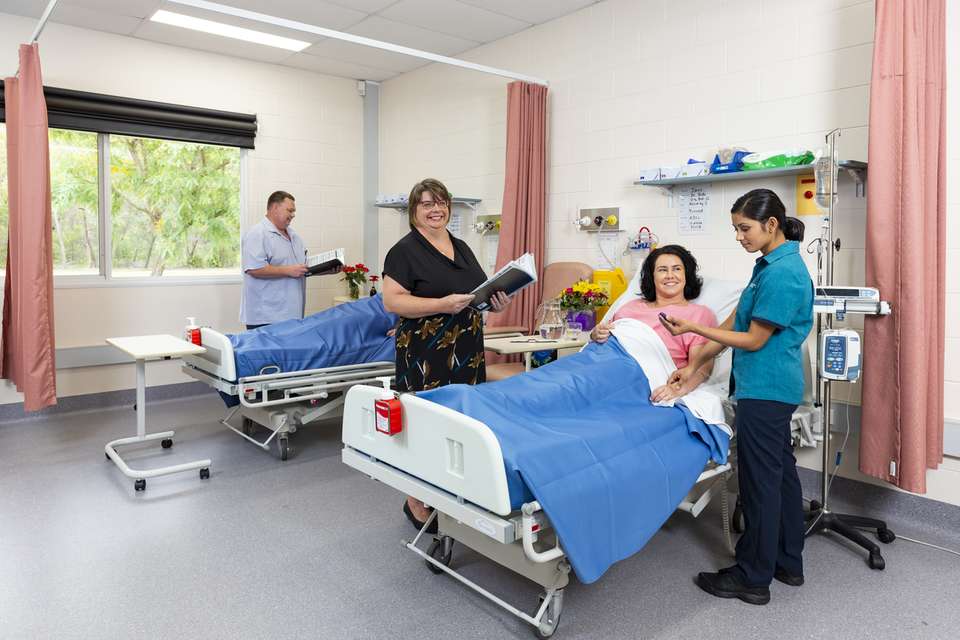 Nursing student attends to patient under guidance of a senior nurse.