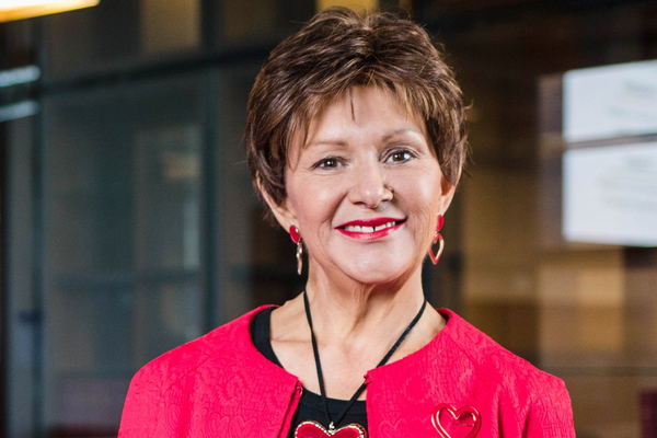 Professor Bronwyn Fredericks in a red jacket and smiling at camera.