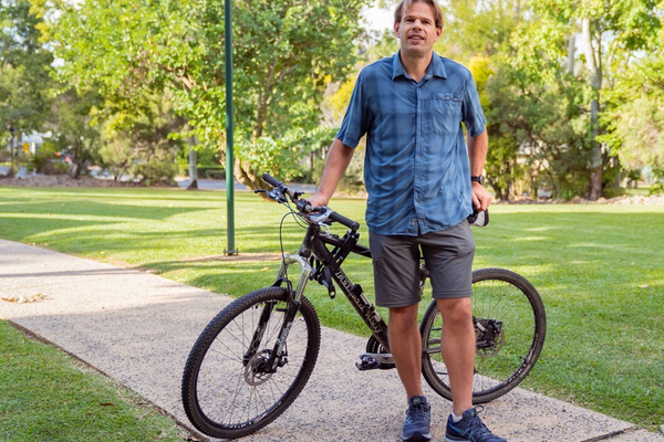 Professor Corneel Vandelanotte standing in front of a bike.