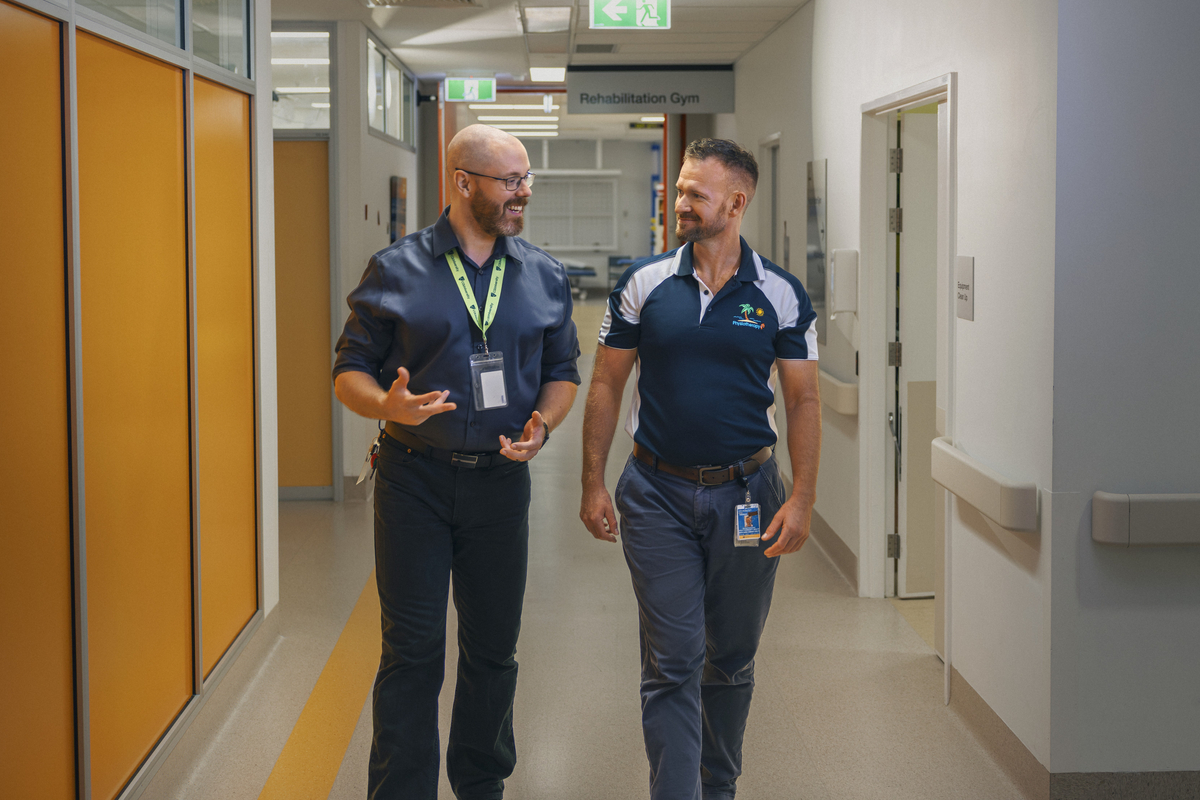 CQU staff member walking with an industry leader down a hallway