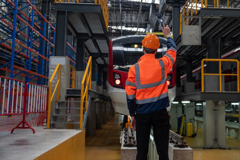 Rail worker standing in front of train