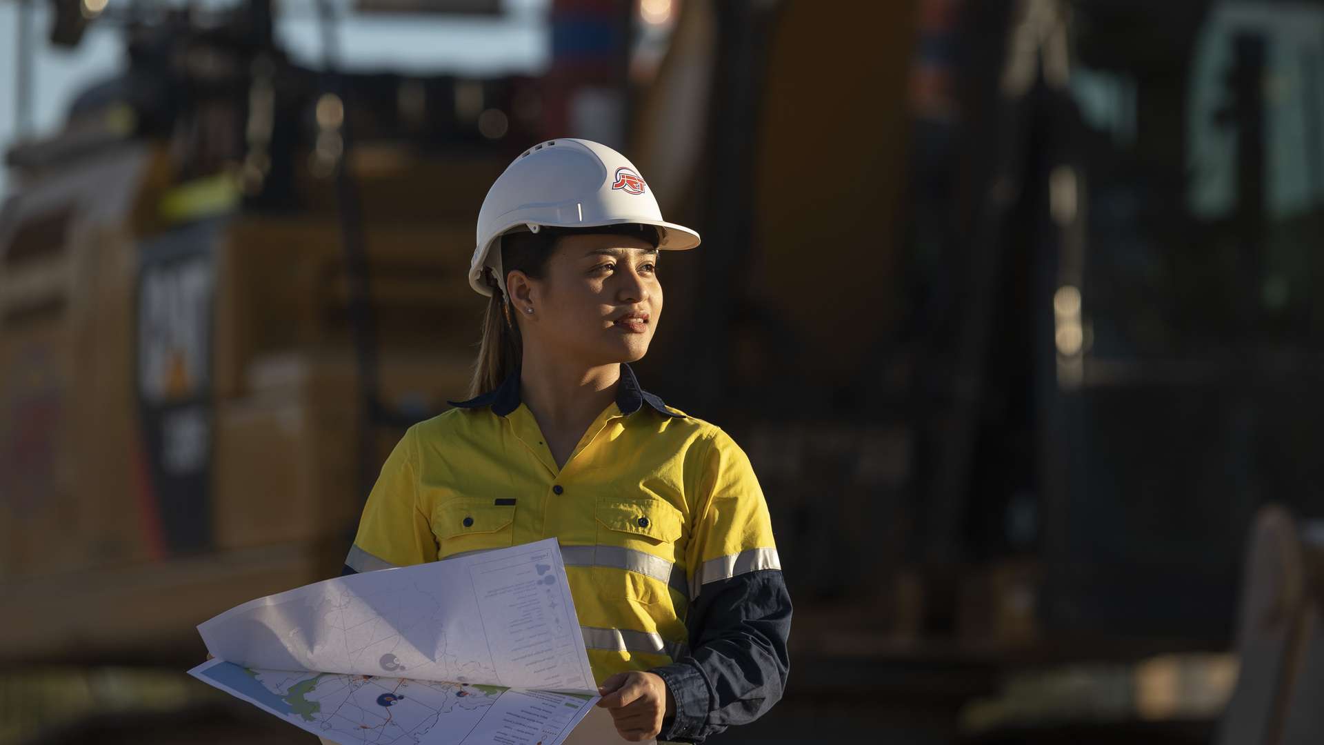 CQU Resource Systems Engineering student on mine site with engineering plans.