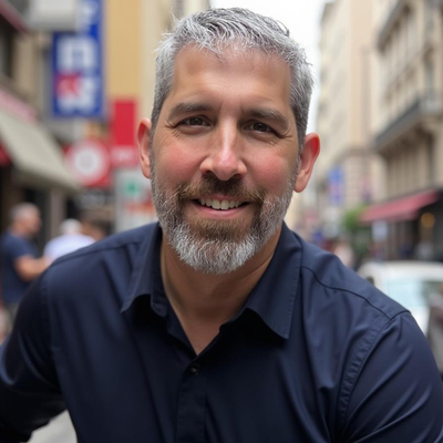 Headshot of Dr Robert Vanderburg wearing a blue buttoned up shirt, smiling at the camera
