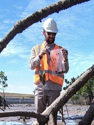 Rory Mulloy in PPE collecting samples from mudflats
