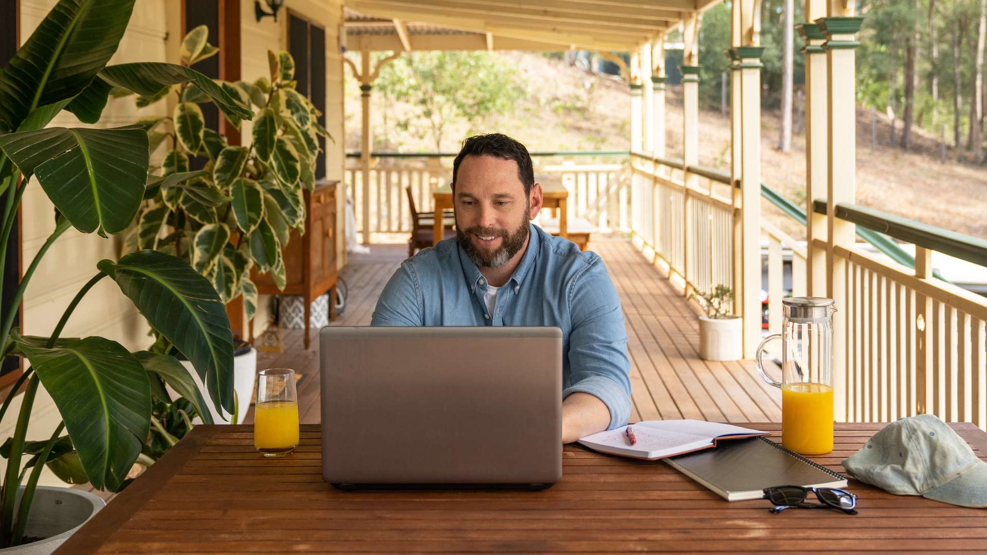 Student sitting on veranda studying online with a laptop