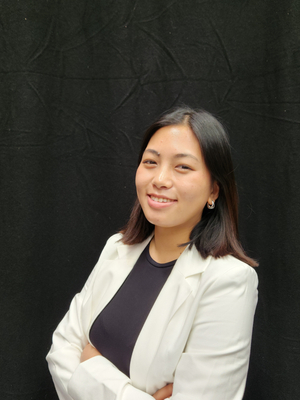 Sahisa Sunuwar stands in front of a dark backdrop with arms crossed.