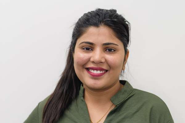 Samata, a student from Nepal, smiling in front of a white background