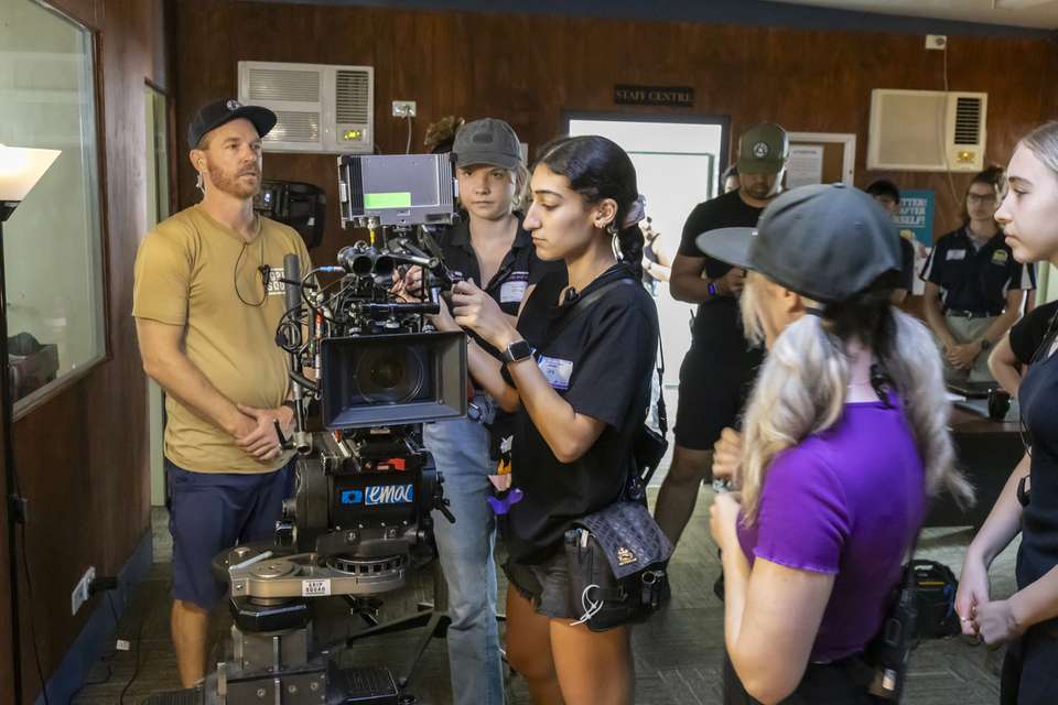 People gathered around a film camera