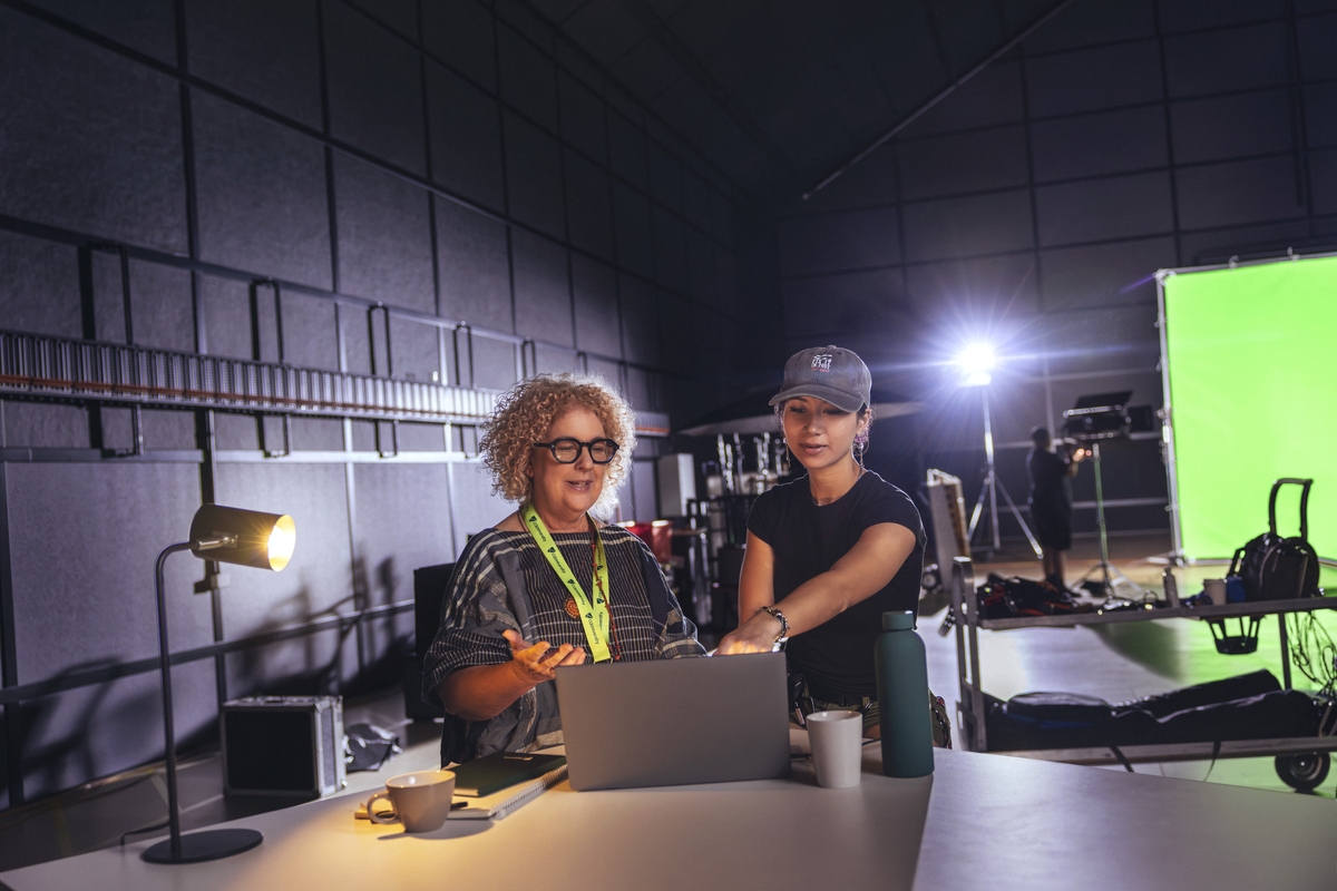 CQU staff member working with crew member on a film set