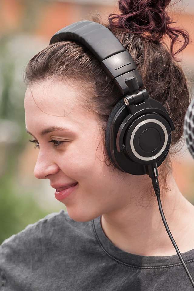 Women wearing headphones looking off camera to her right
