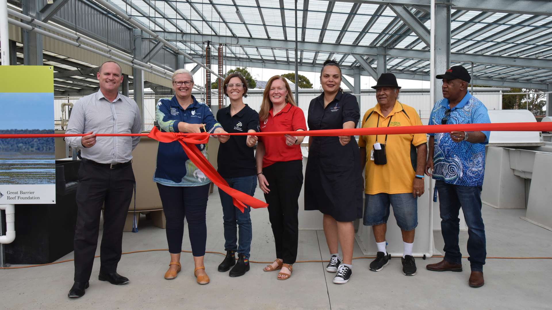 CQU executives, CMERC staff and community members standing at SeaGrow cutting the opening ribbon