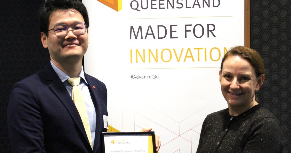 Dr Qing Wu receives his Advance Queensland certificate from Queensland Chief Scientist Professor Kerrie Wilson in front of Advance Queensland banner.JPG