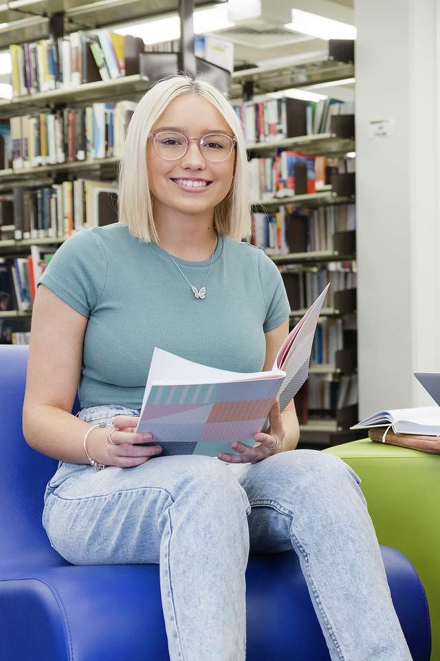Two students study together in the library.