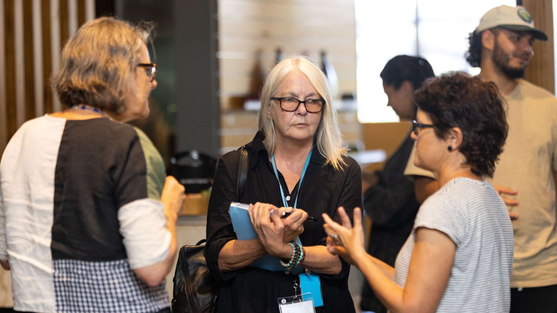 A group of people stand together, engaged in conversation.