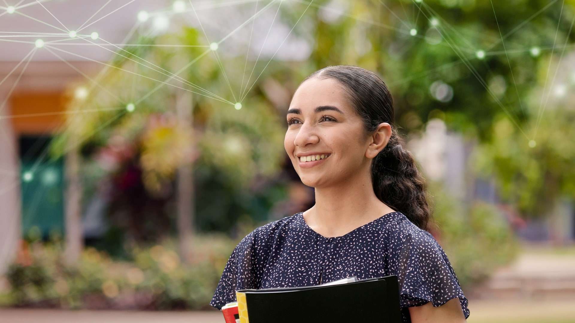 Tyla stands on campus looking into the distance with digital web graphics super imposed on the image.