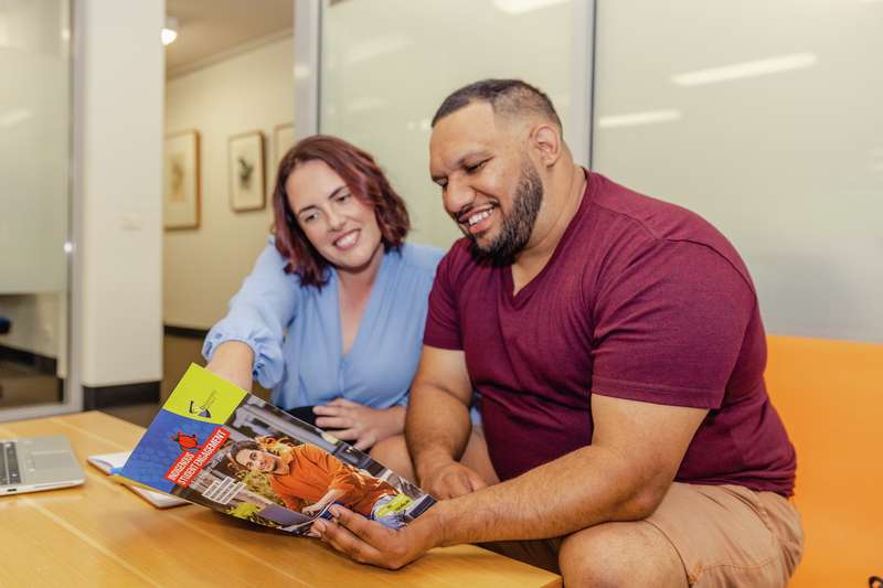 Indigenous staff sitting at a coffee table looking at the Stretch RAP Document