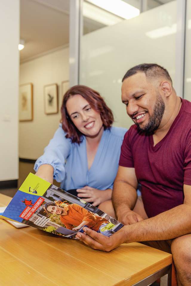 Indigenous staff sitting at a coffee table looking at the Stretch RAP Document