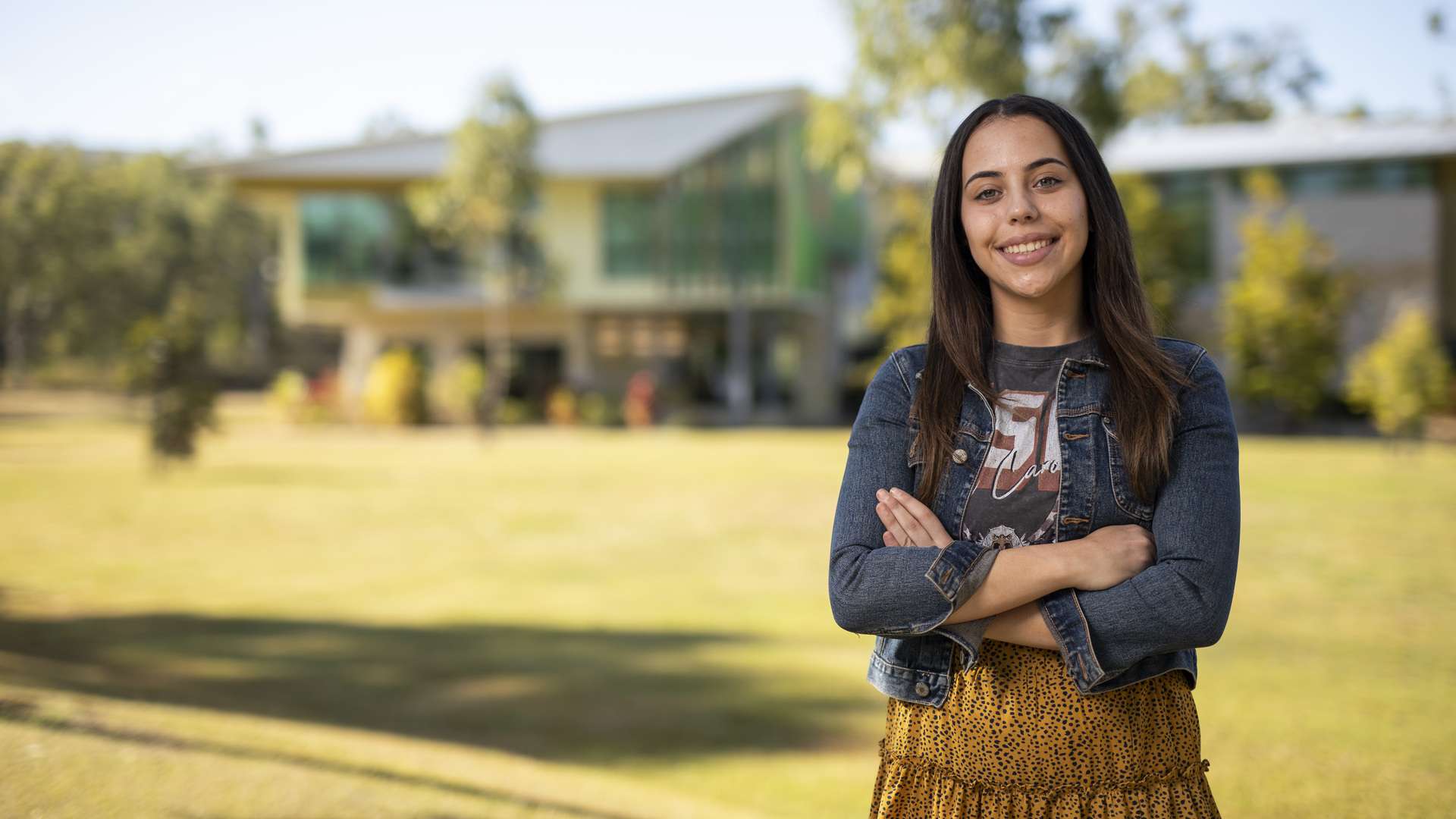 A smiling CQU student on campus on a sunny day