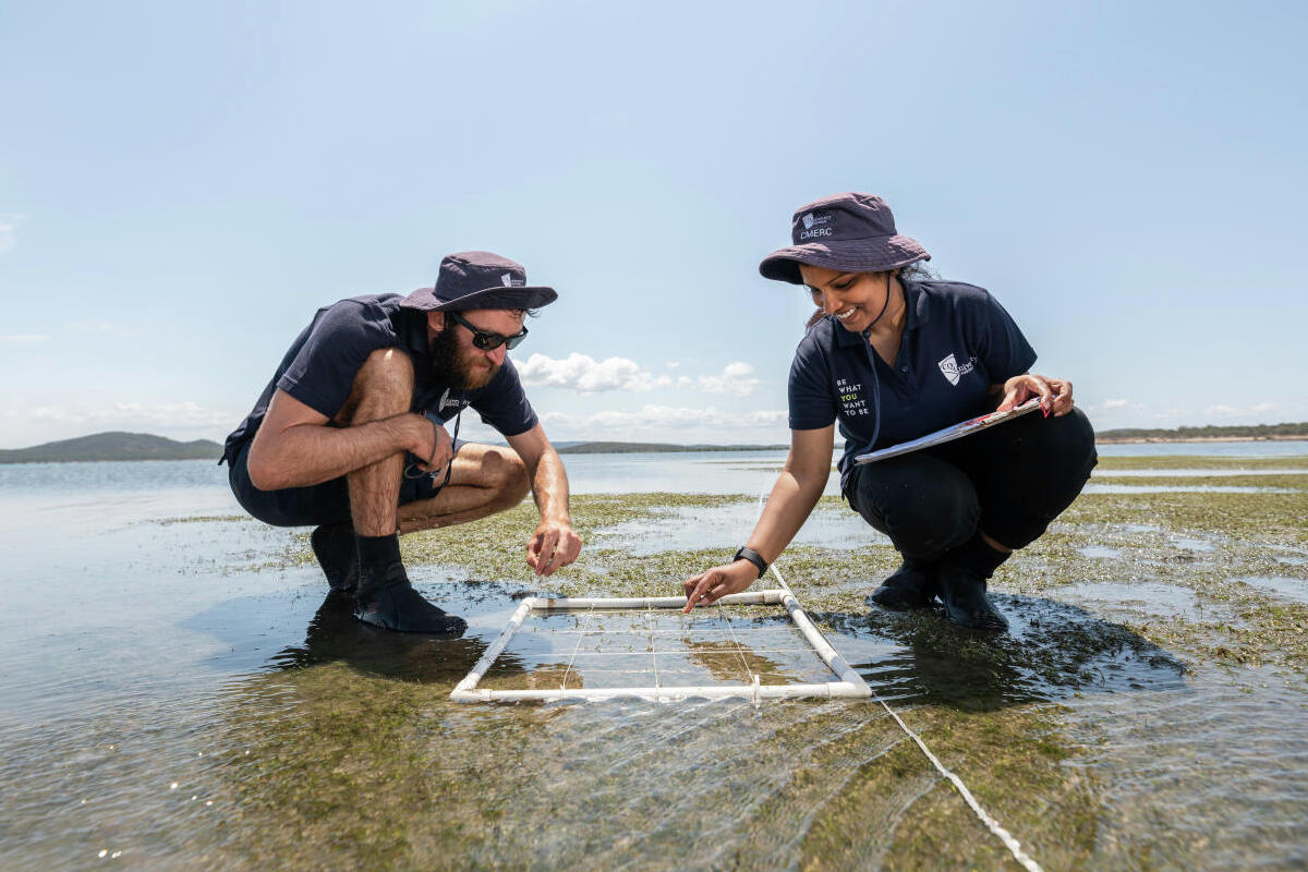 two students working together to measure water with a white rope