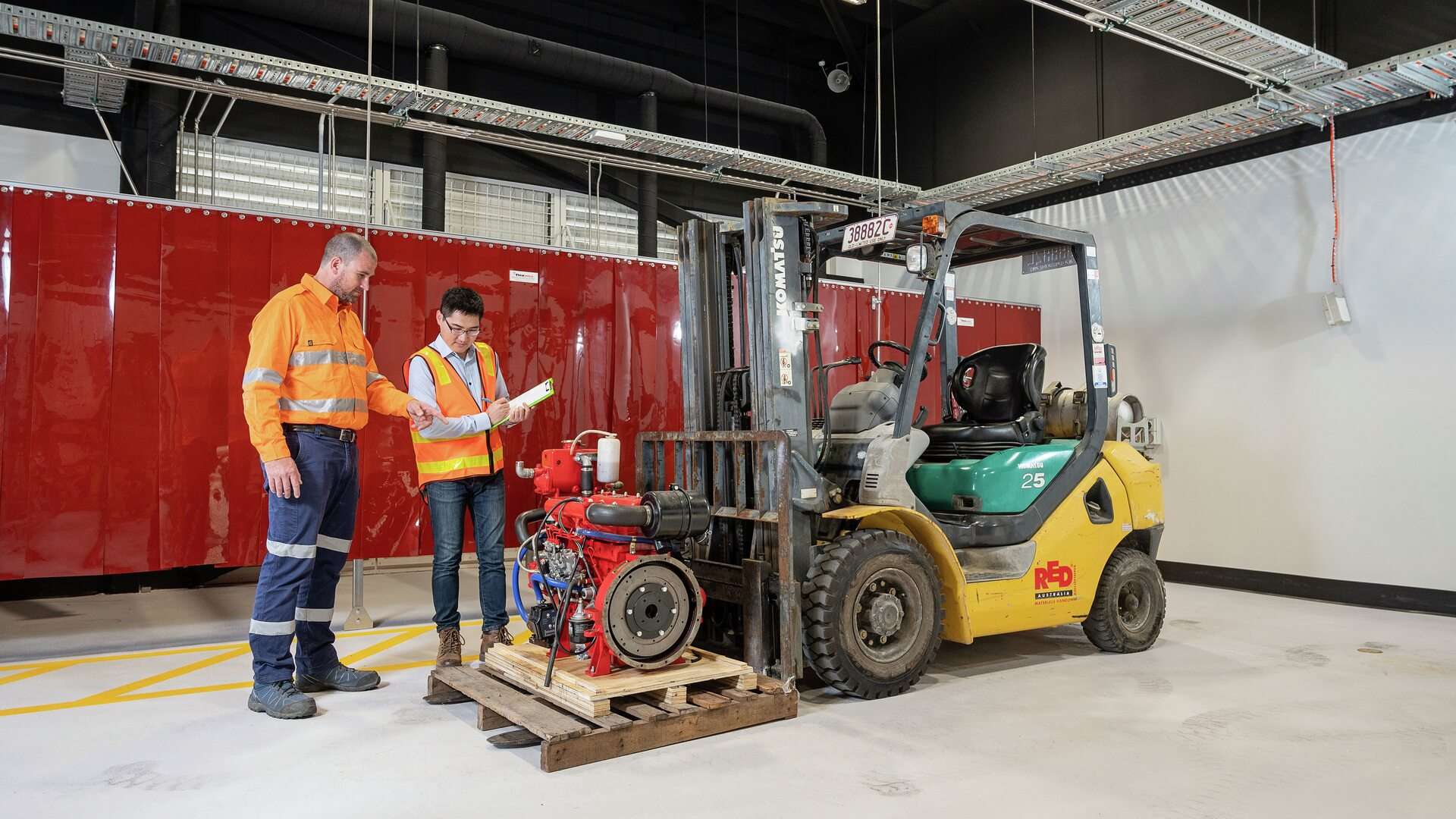 Two workers working with a forklift