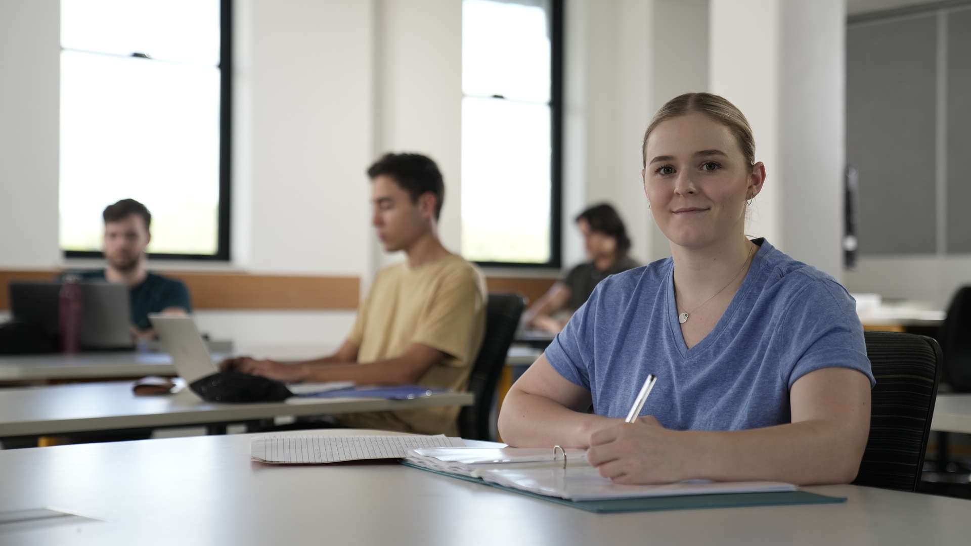CQU student smiling at camera in a classroom.