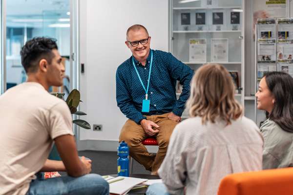 High School students and teachers sitting in a circle having a discussion