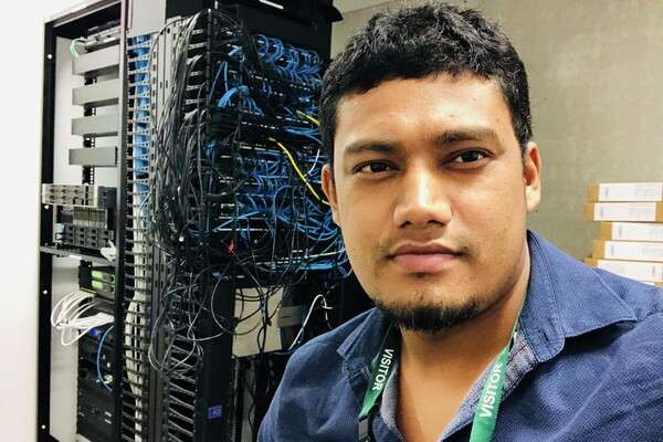 Vikas Shah, from Nepal, smiling in front of Internal Network Wiring