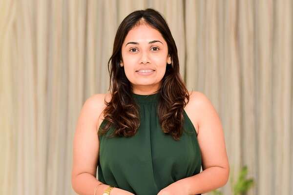 International student Abeykoon Mudiyanselage Vindhya Shivanthi Abeykoon from Sri Lanka wearing a green and black dress and hands clasped.