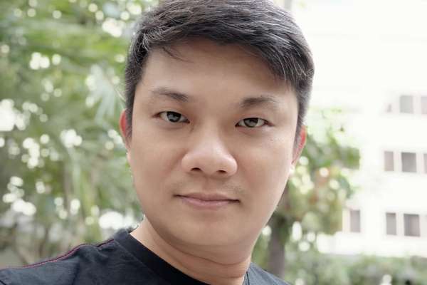 Indonesian, online student Wie Kiang Hi smiling in a residential area