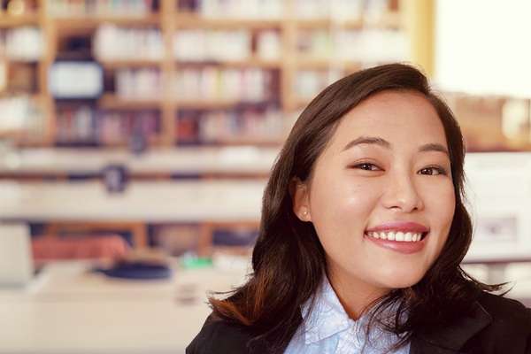 Yasna Gurung smiling in a library