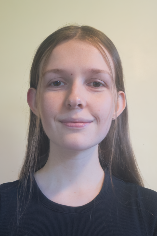 Alumna Zara Costello smiling at the camera wearing a black top